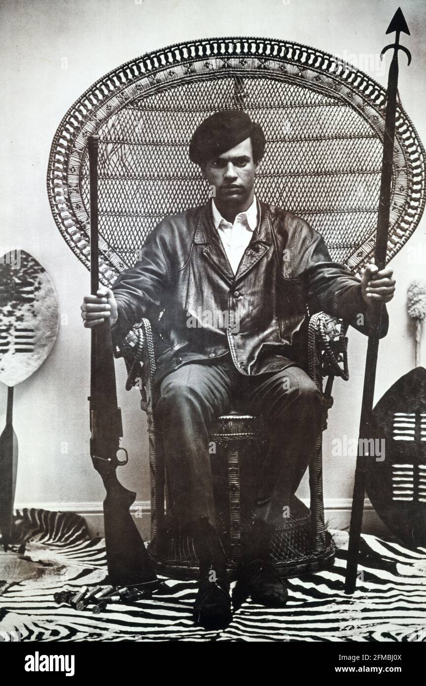 Die rassistischen Hundepolizisten müssen sich sofort aus unseren Gemeinden zurückziehen, ihren mutwilligen Mord und ihre Brutalität einstellen. Das Poster zeigt ein Porträtfoto von Blair Stapp von Huey Newton, der mit einem Gewehr und einem Speer auf einem Rattan-Thronstuhl sitzt. Namen der Mitwirkenden Black Panther Party, Sponsor/Inserent Stapp, Blair, Fotograf erstellt/veröffentlicht [zwischen 1965 und 1980] Themenüberschriften - Newton, Huey P - Afrikanische Amerikaner - Polizei--1960-1980 - Aktivisten--1960-1980 Stockfoto