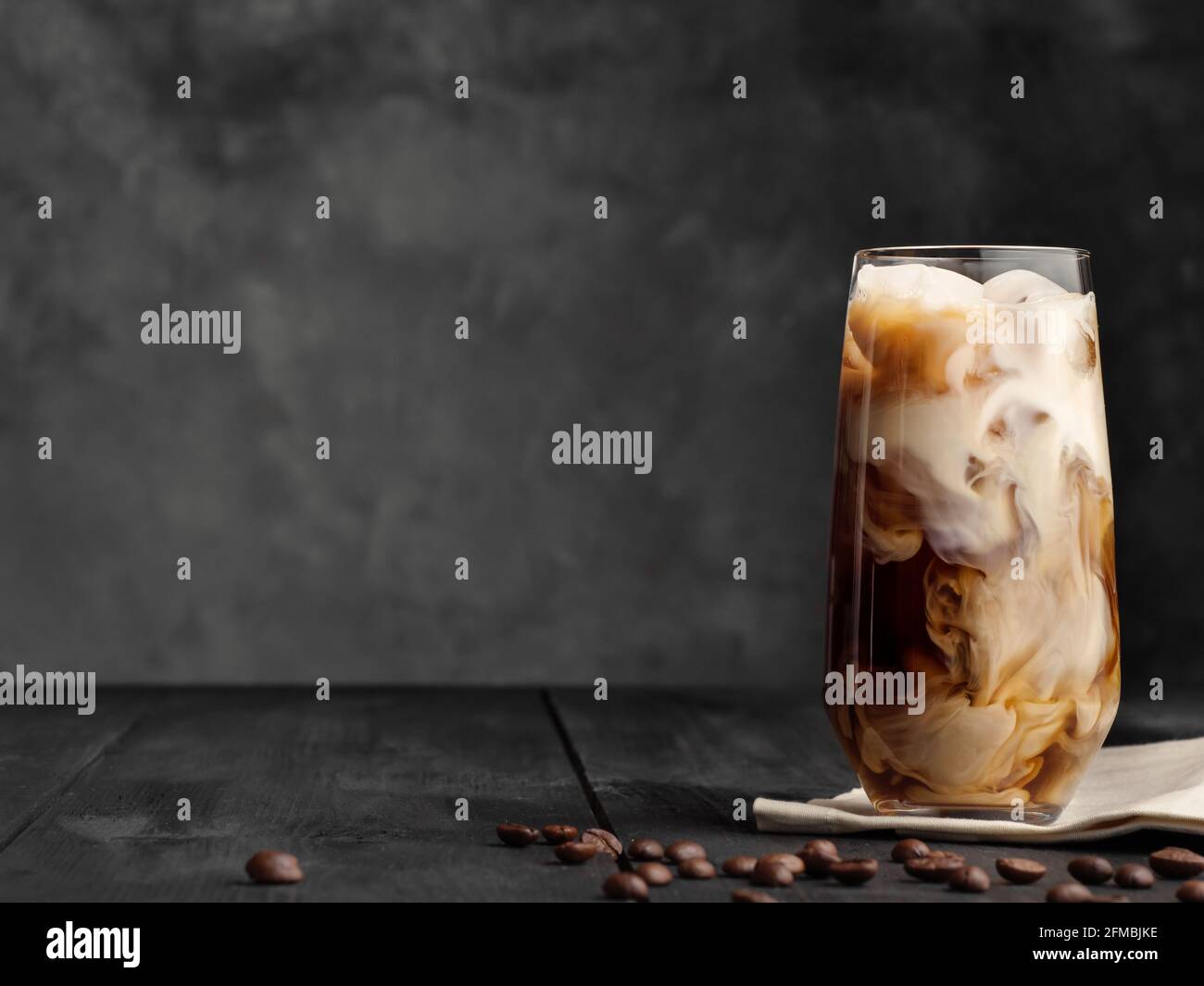 Eiskaffee und Milch in einem Longdrinkglas auf dem Tisch. Speicherplatz kopieren. Stockfoto