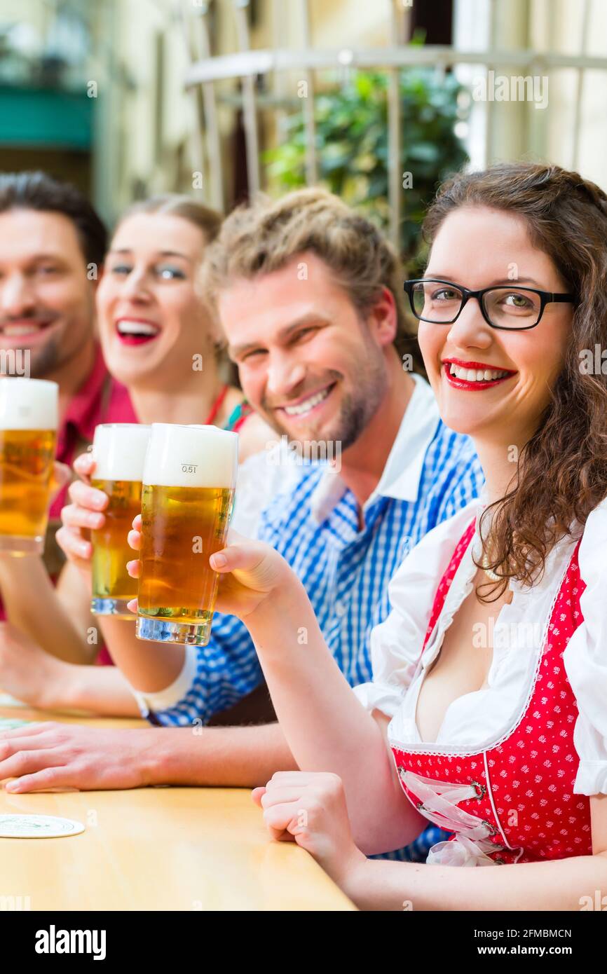 Freunde in traditioneller bayerischer Tracht in Restaurant oder Pub mit Bier in Bayern, Deutschland Stockfoto