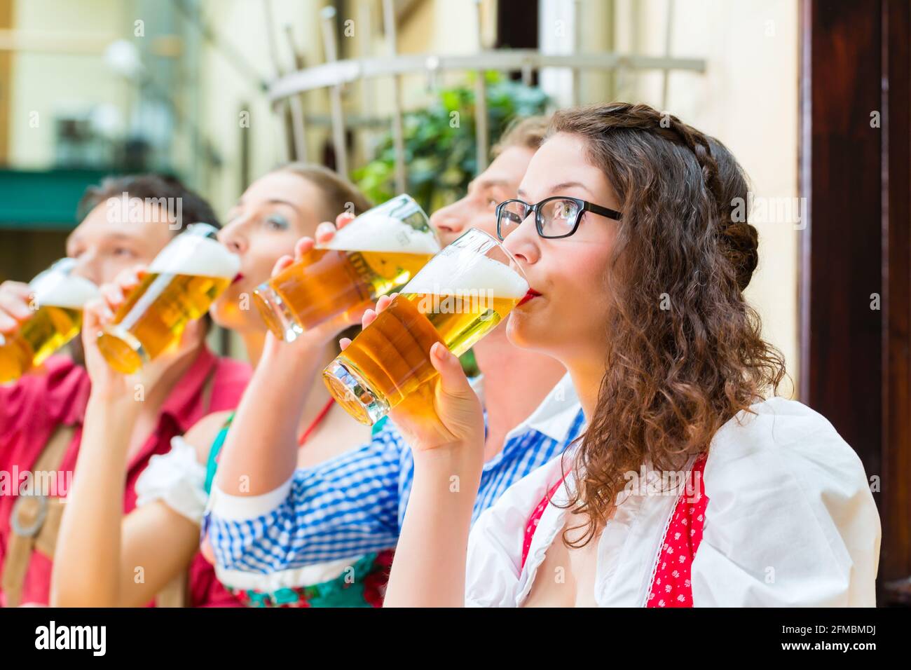 Freunde in traditioneller bayerischer Tracht in Restaurant oder Pub mit Bier in Bayern, Deutschland Stockfoto