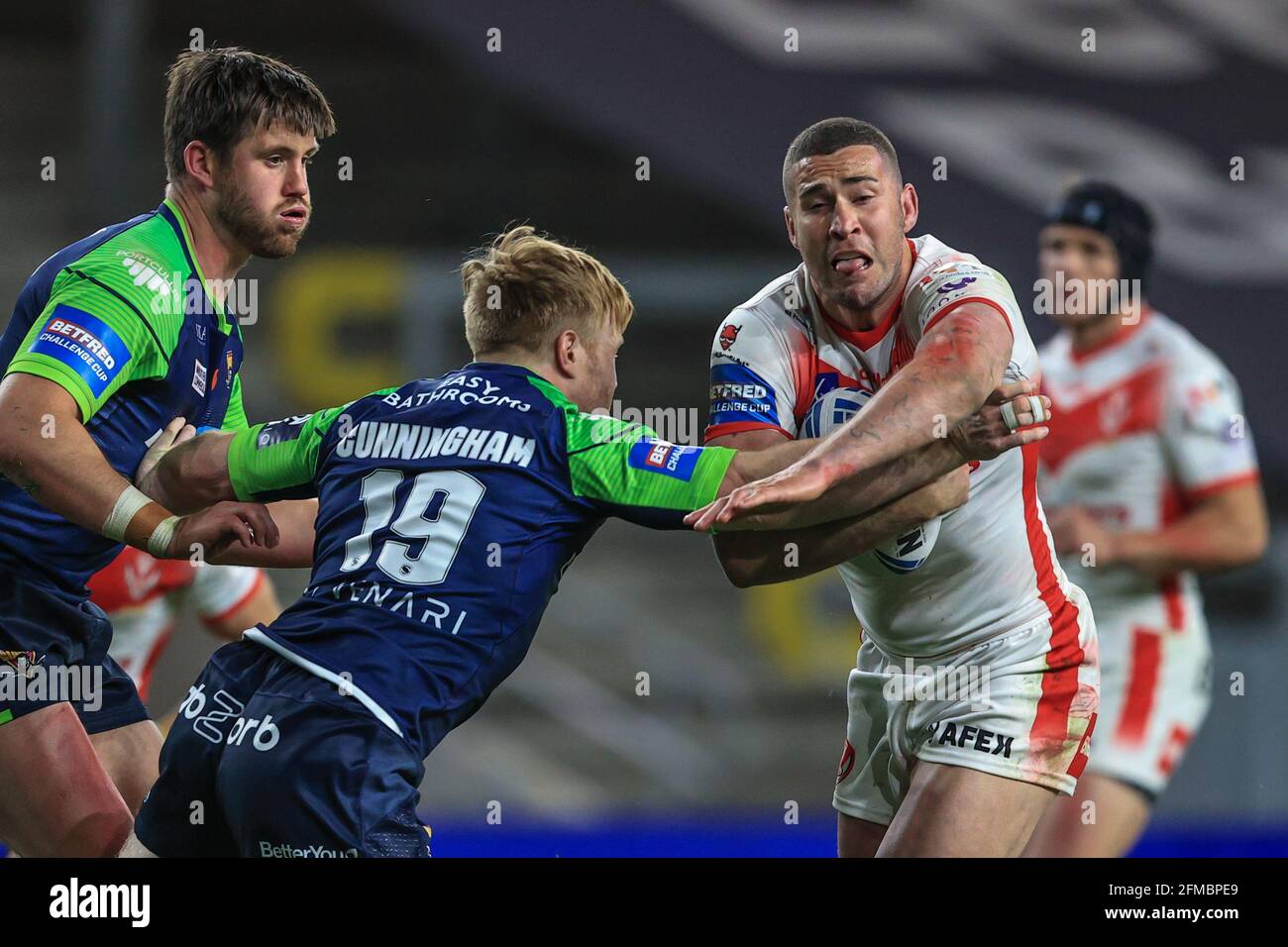 Joel Thompson (11) aus St. Helens wird von James angegangen Cunningham (19) von Huddersfield Giants Stockfoto