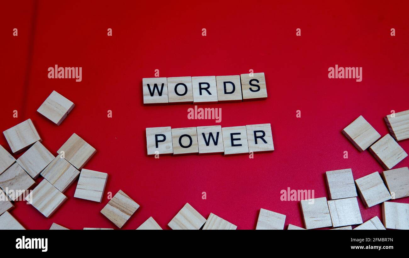 Selektiver Fokus eines Holzblocks mit einem Text der Die Macht der Worte auf einem roten Hintergrund isoliert Stockfoto