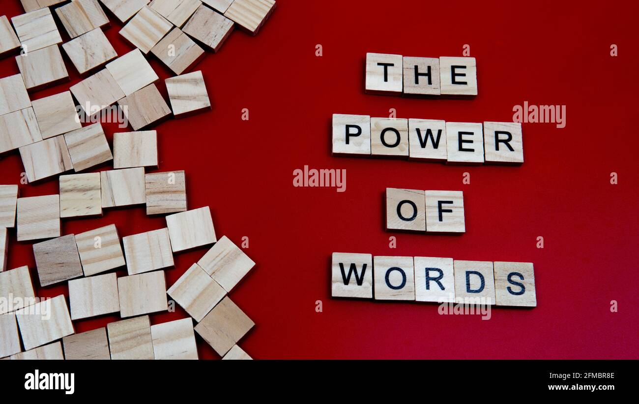Selektiver Fokus eines Holzblocks mit einem Text der Die Macht der Worte auf einem roten Hintergrund isoliert Stockfoto