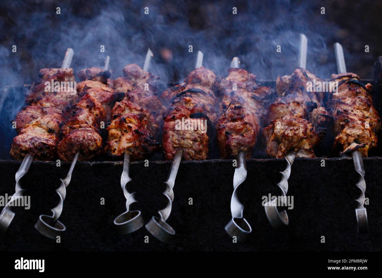 Kebabs werden auf Spießen auf dem Grill gebraten Stockfoto