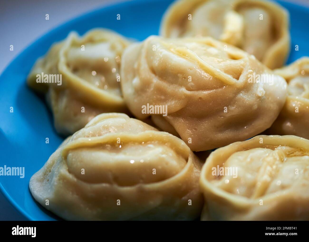 Köstliche Manti liegen auf einem blauen Teller Stockfoto