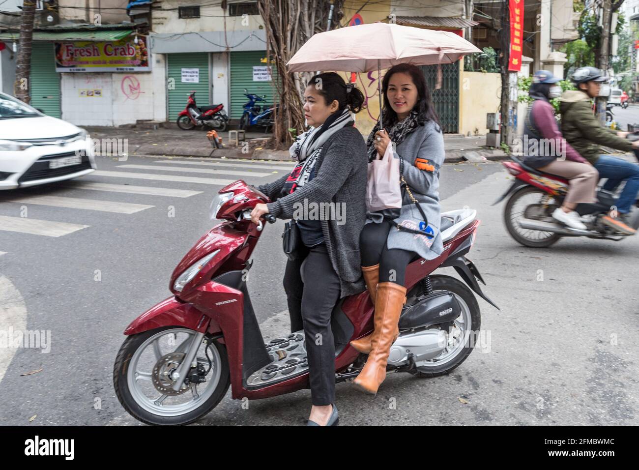 Motorradtransport, mit Regenschirm zum Schutz vor Regen oder Sonne, Blick  auf die Straße, Hanoi, Vietnam Stockfotografie - Alamy