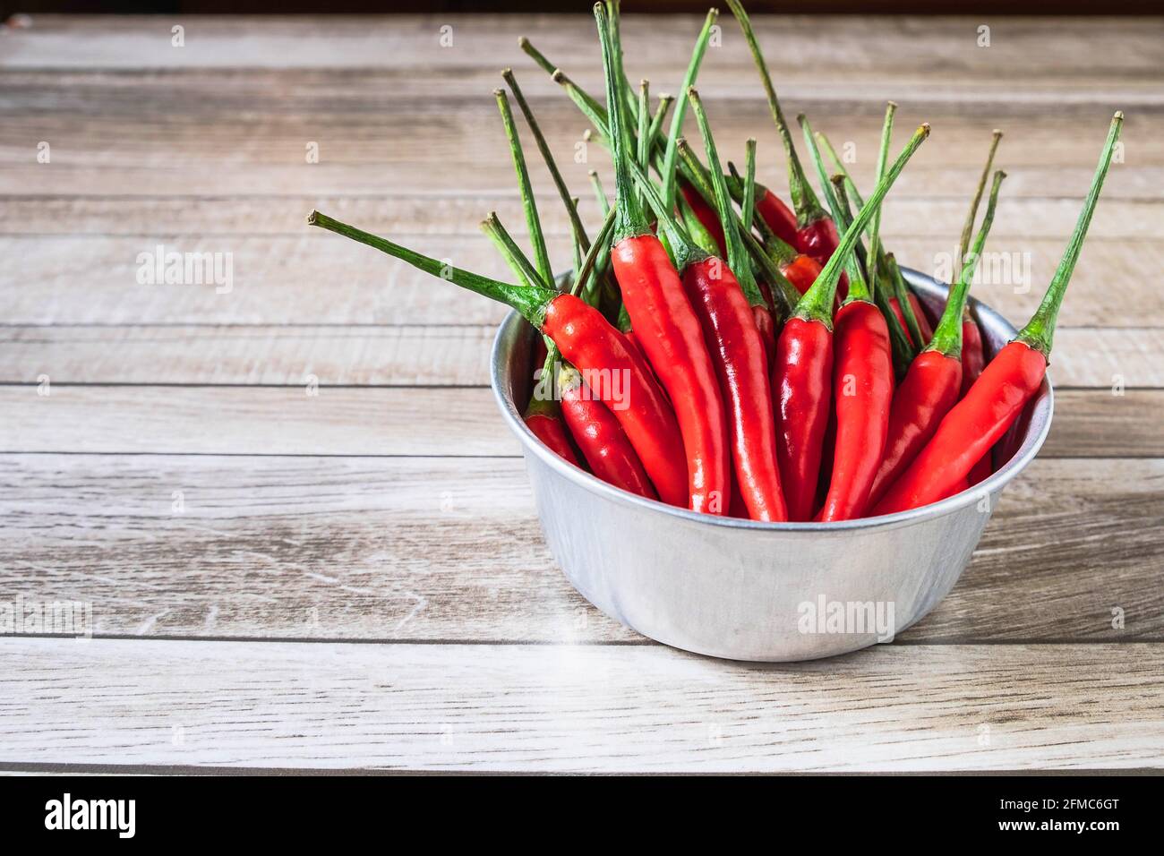 Rote Chili in einer Schüssel auf einem Holztisch Stockfoto