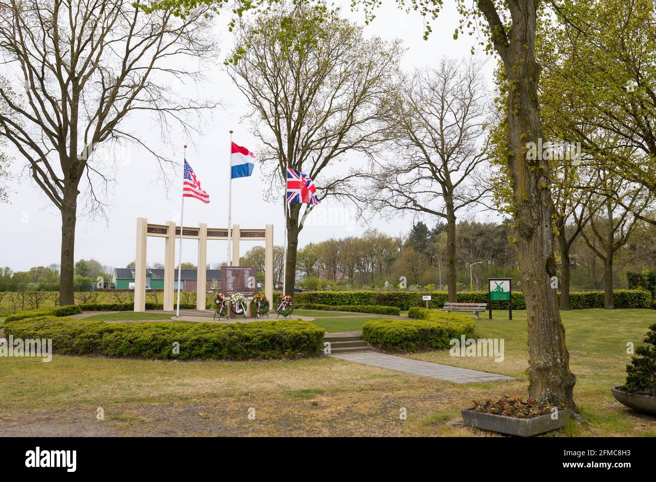 US-, britische und niederländische Flagge winkt am Gedenkmonument für gefallene Soldaten und Zivilisten während der Befreiung von Liessel, Niederlande Stockfoto