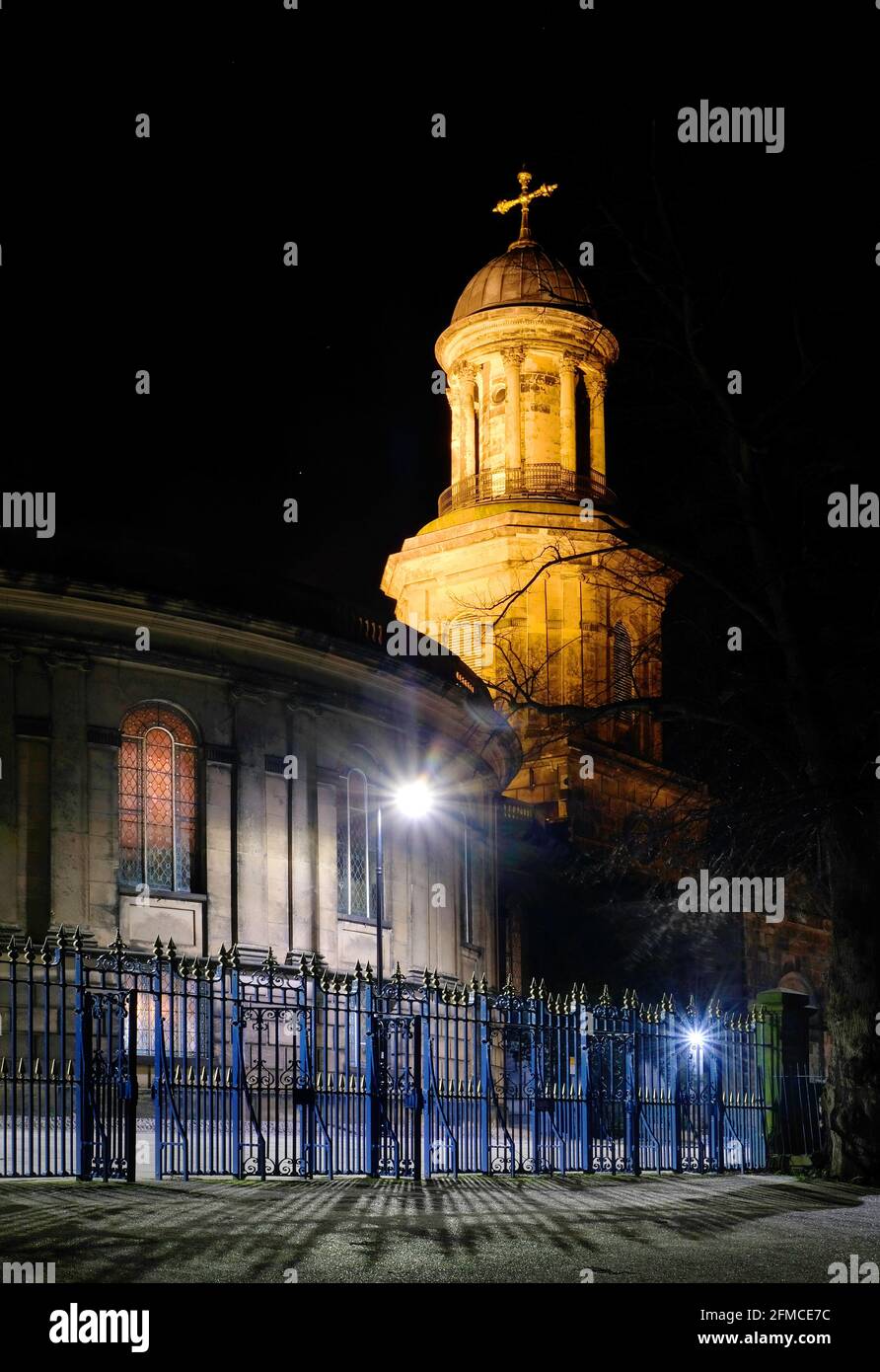 Kirche des Heiligen Tschad, Shrewsbury Shropshire, Großbritannien, bei Nacht. Der Tschad ist einzigartig, weil er rund ist. Die gusseisernen Tore des Steinbruchs im Vordergrund Stockfoto