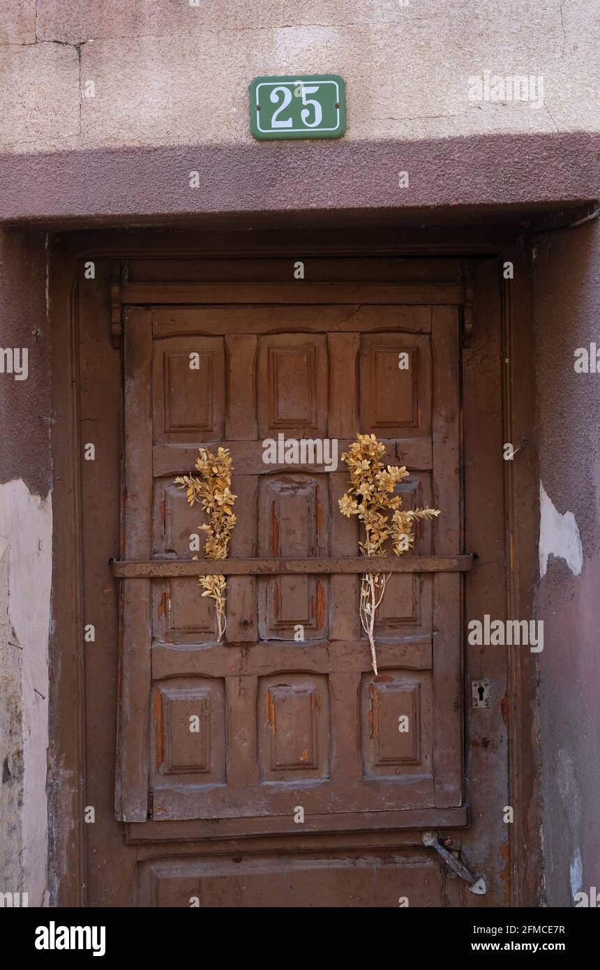Ein Talisman aus getrockneten Blumen auf einem geschlossenen braunen Türverschluss eines Hauses in Libros, in der Nähe von Teruel, Aragon, Spanien Stockfoto