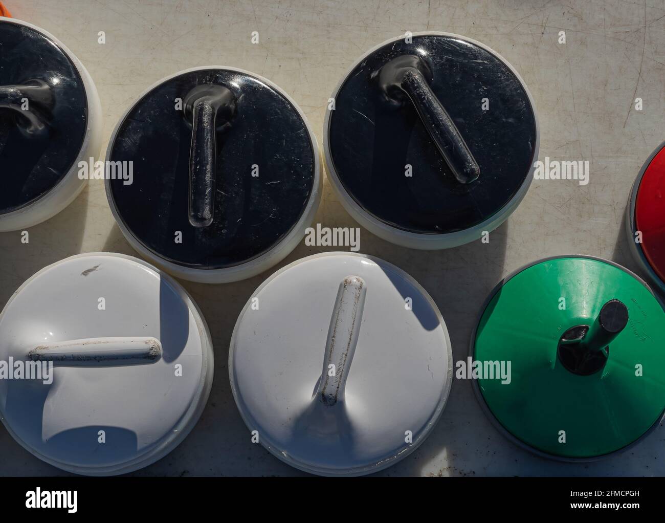 Nahaufnahme von bunten Eisstocksteinen auf dem Eisfeld Stockfoto