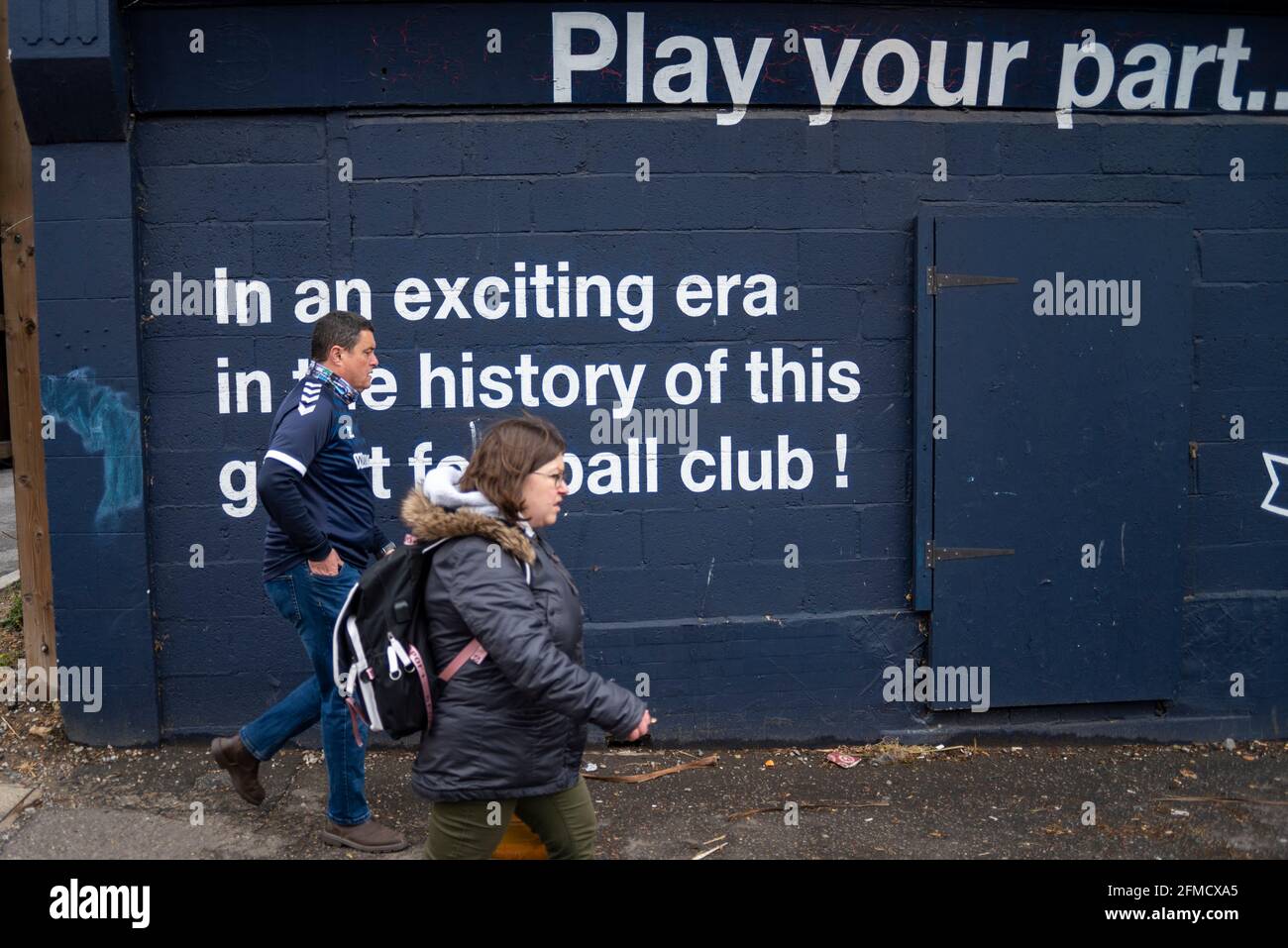 Roots Hall, Southend on Sea, Essex, Großbritannien. Mai 2021. Im Fußballverein Southend United, der aus der zweiten Liga in den Status einer anderen Liga abgesetzt wurde, findet ein Protest statt. Die Fans beschuldigen den Vorsitzenden Ron Martin, dass er sich auf die Entwicklung von Roots Hall in Wohnungen und einen Umzug in ein geplantes neugebautes Stadion auf Fossetts Farm auf Kosten des Teams konzentriert hat. Unterstützer befürchten, dass Roots Hall ohne Garantie für ein neues Zuhause entwickelt werden könnte, was die Zukunft des Clubs riskiert. Besucher Newport County wetteifern um einen Play-off-Platz. Fan, der an einem Versprechen von besseren Zeiten vorbeiläuft, die nicht erfüllt sind Stockfoto