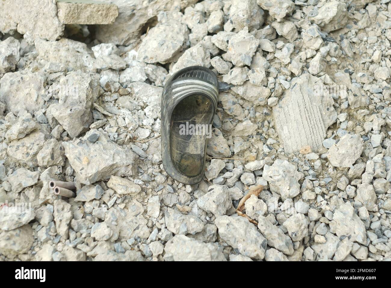 Auf den Zementhaufen wurden alte Schuhe geworfen. Stockfoto