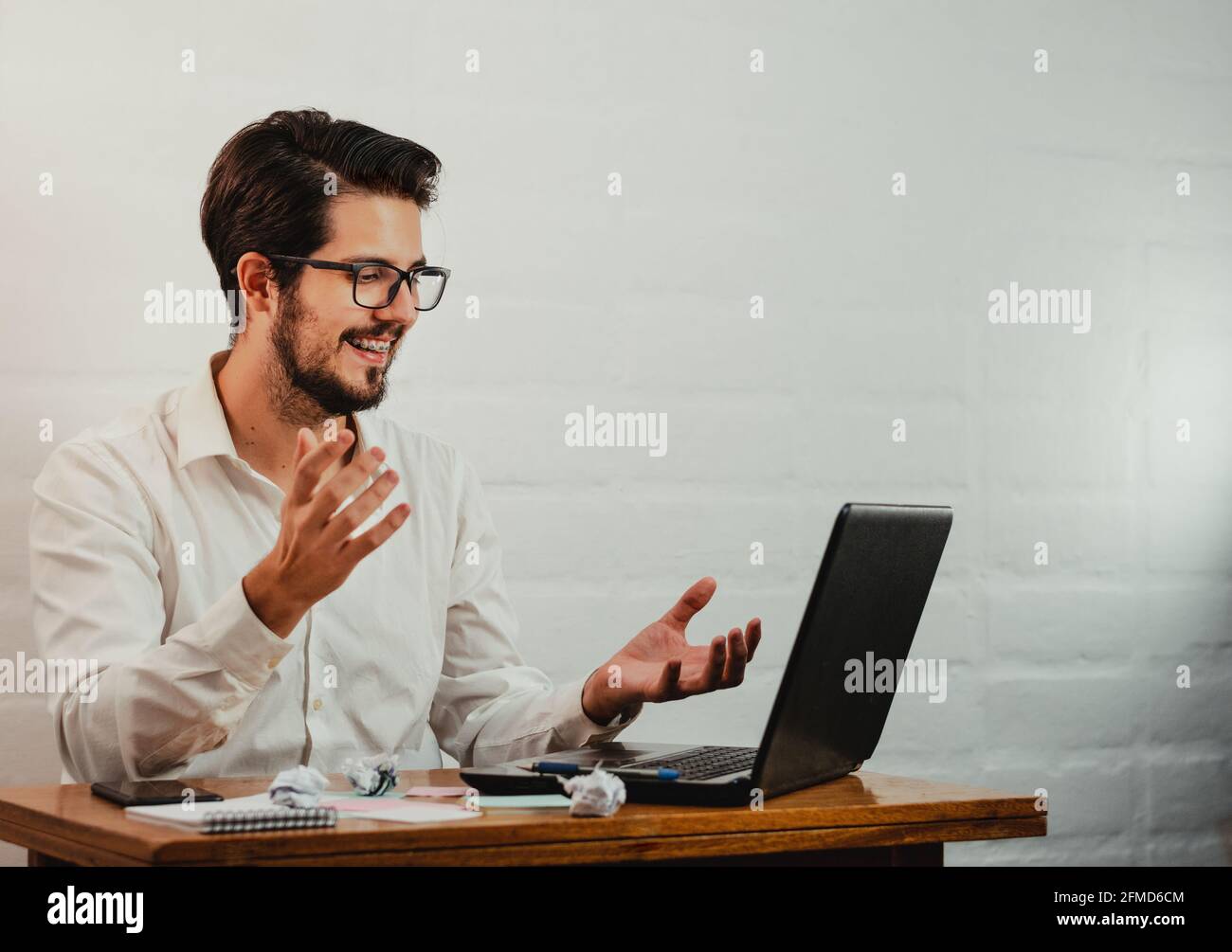 Junger kaukasischer Mann, der während der Arbeit in einen Videoanruf führt Büro Stockfoto