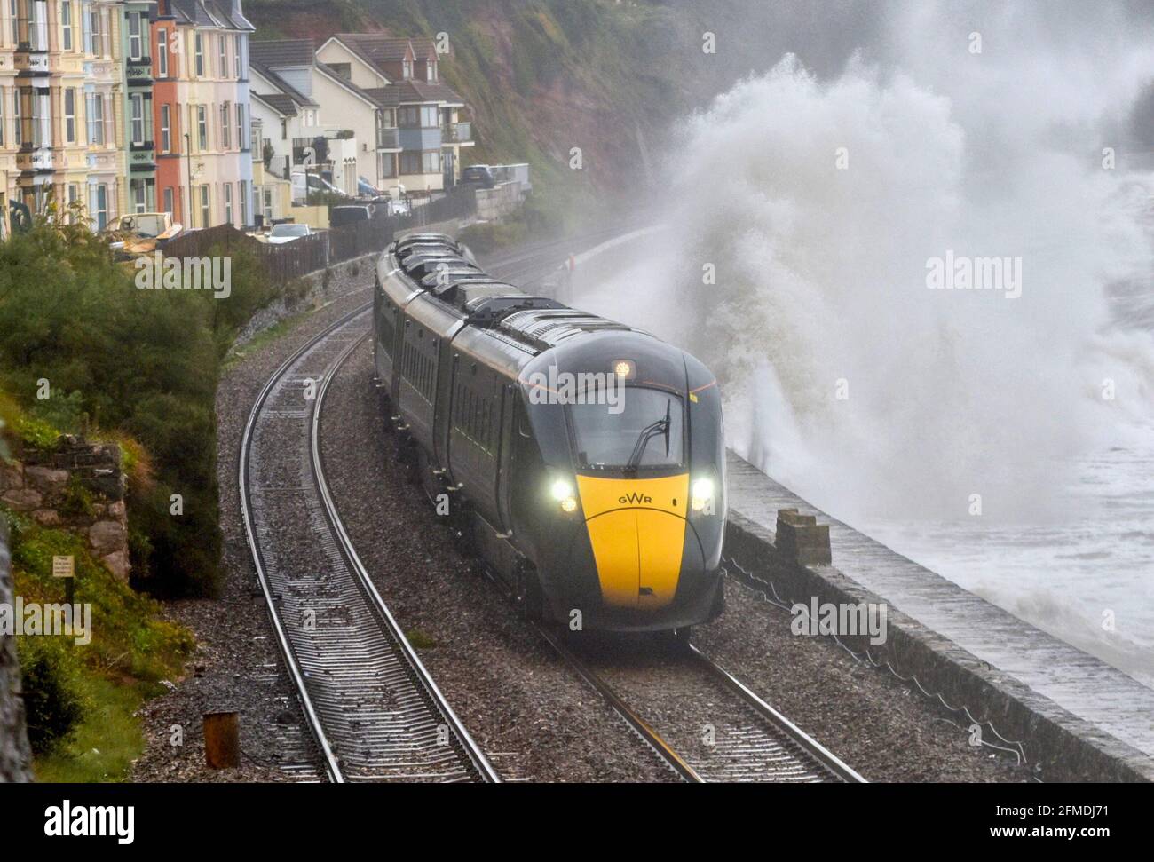 Ein Zug der Great Western Railways Hitatchi der Klasse 800 fährt bei stürmischem Wetter entlang der renovierten Dawlish-Ufermauer. GWR. Stockfoto