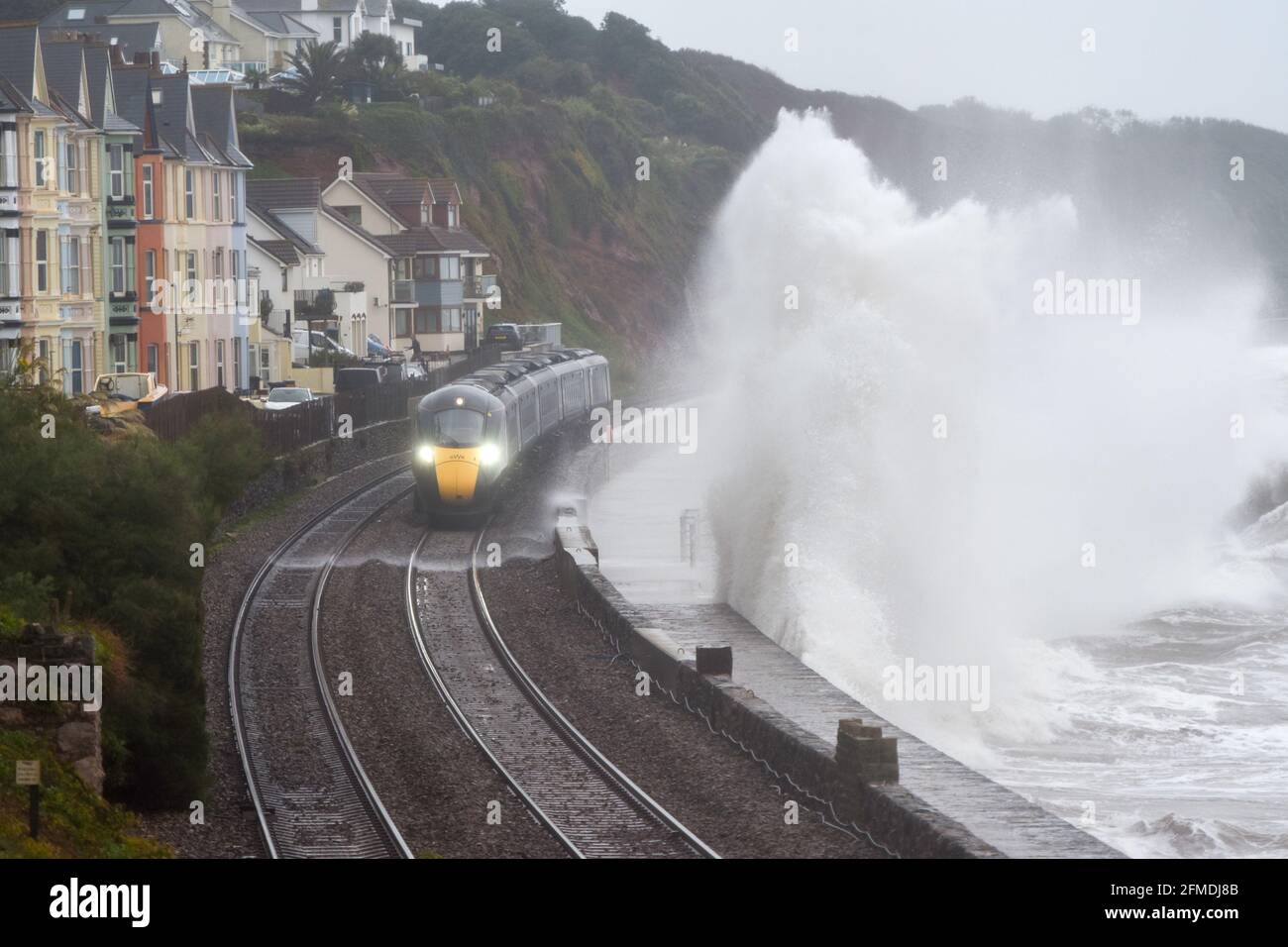 Ein Zug der Great Western Railways Hitatchi der Klasse 800 fährt bei stürmischem Wetter entlang der renovierten Dawlish-Ufermauer. GWR. Stockfoto