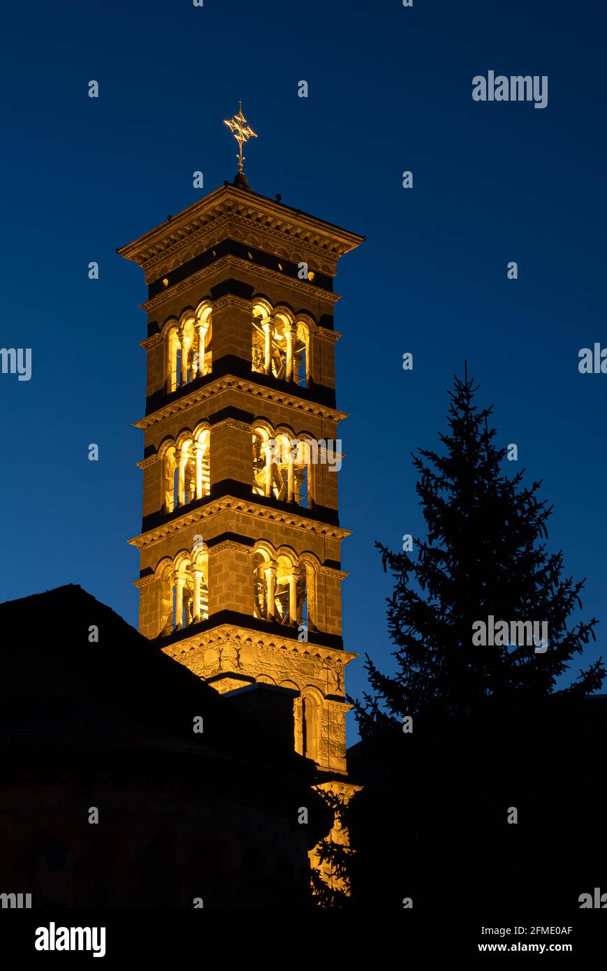 St. Moritz, Schweiz - 26. November 2020: Beleuchteter Glockenturm der katholischen Kirche St. Mauritius in der blauen Stunde Stockfoto