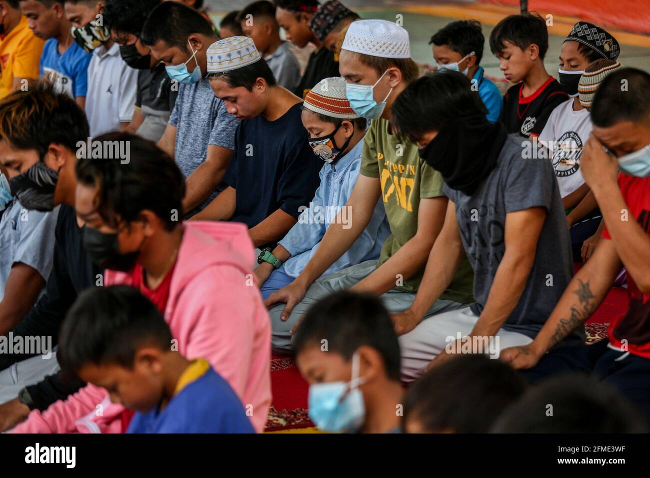 Marikina Stadt, Philippinen. Mai 2021. Philippinische Muslime, die als Vorsichtsmaßnahme gegen den Ausbruch des Coronavirus Schutzmasken tragen, versammeln sich, während sie an einem Mittagsgebet zur Beobachtung des Ramadan in einer muslimischen Gemeinschaft teilnehmen. Stockfoto