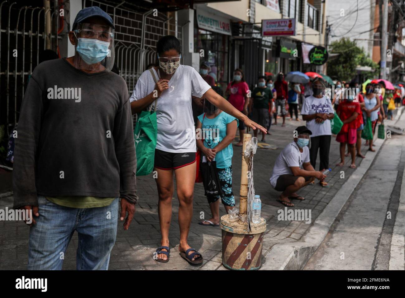 Die Bewohner stehen Schlange, um kostenlose Waren aus einer Quarantäne der Gemeinschaft zu sammeln, die von den Missionsschwestern vom Sacro Costato und der schmerzhaften Mutter (MSC) in Quezon City angeboten wird. Kirchliche Gruppen haben ihre Unterstützung für die wachsende Zahl von gemeindengeführten Vorratskammern bekundet, die Menschen, die von der COVID-19-Pandemie betroffen sind, kostenlose Nahrung zur Verfügung stellen, trotz Anschuldigungen von Gesetzeshütern wie kommunistischen Rebellen oder Unterstützern des langjährigen linken Aufstands im Land. Metro Manila, Philippinen. Stockfoto
