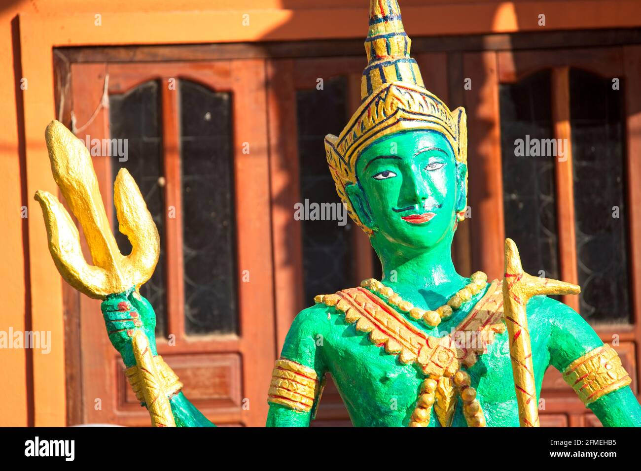 Nahaufnahme der farbenfrohen grünen shiva-Statue mit Dreizack im Kloster Muang La, Laos. Stockfoto
