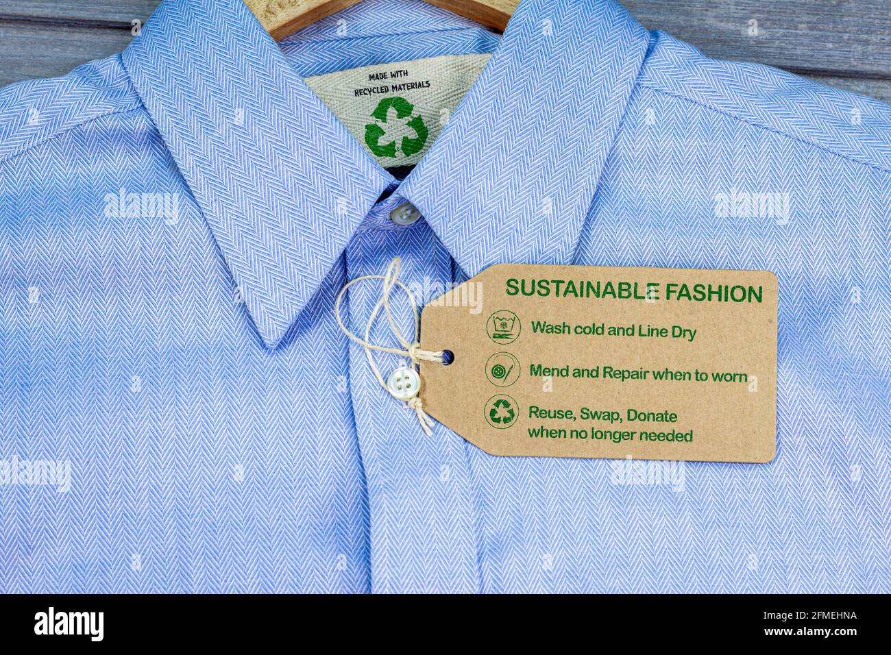 Hergestellt aus recycelten Materialien Hemd mit nachhaltigem Fashion Care Label, Mode kalt waschen, Linie trocken, reparieren und reparieren, wiederverwenden, Tauschen oder spenden Sie mit Symbolen Stockfoto