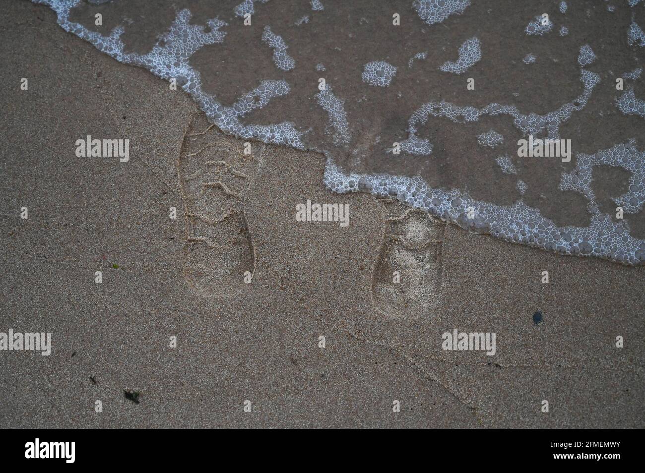 Teilweise gewaschener Schuhdruck an der Küste Stockfoto