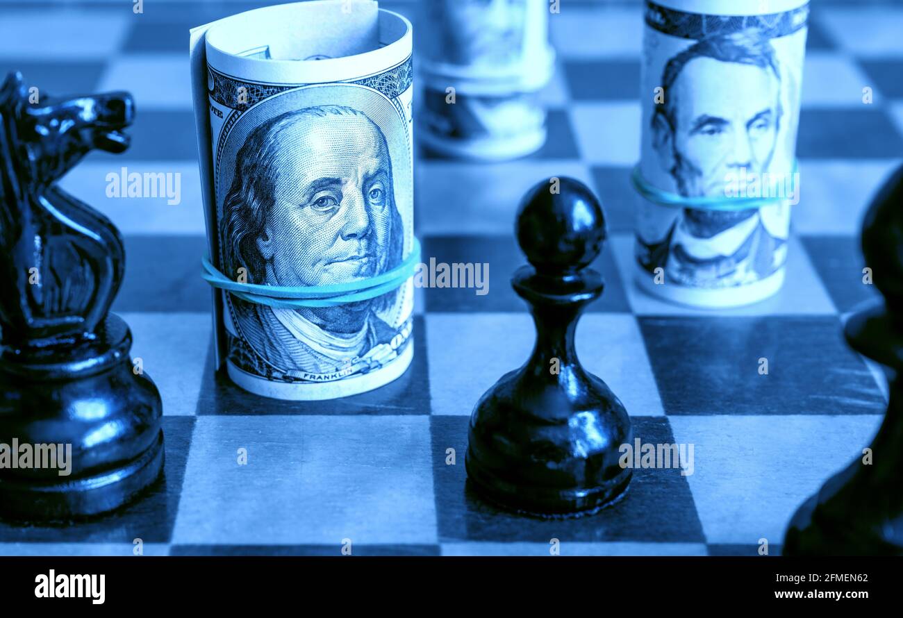 Dollarscheine und Schach, US-Bargeld auf Schachbrett in blauem Licht. Finanzen Symbole und Spiel. Konzept von Geldstrategie, Investitionen, unfairer Schachwettbewerb Stockfoto