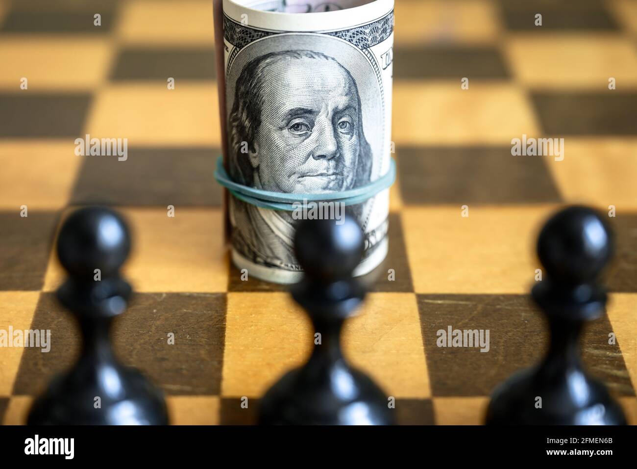 Dollarschein mit Franklin gegen Schachfiguren, US-Bargeld auf Holzbrett. Finanzsymbol und Schachspiel. Konzept der Geldstrategie, Investition, U Stockfoto
