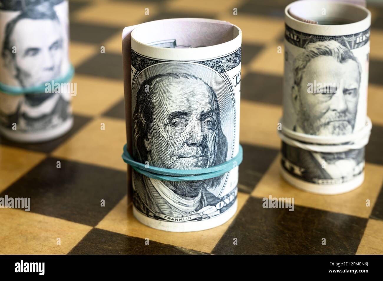 Dollarscheine und Schach, US-Bargeld auf Holzbrett. Finanzen Symbole und Spiel. Konzept von Geldstrategie, Investitionen, unfairer Schachwettbewerb, econo Stockfoto