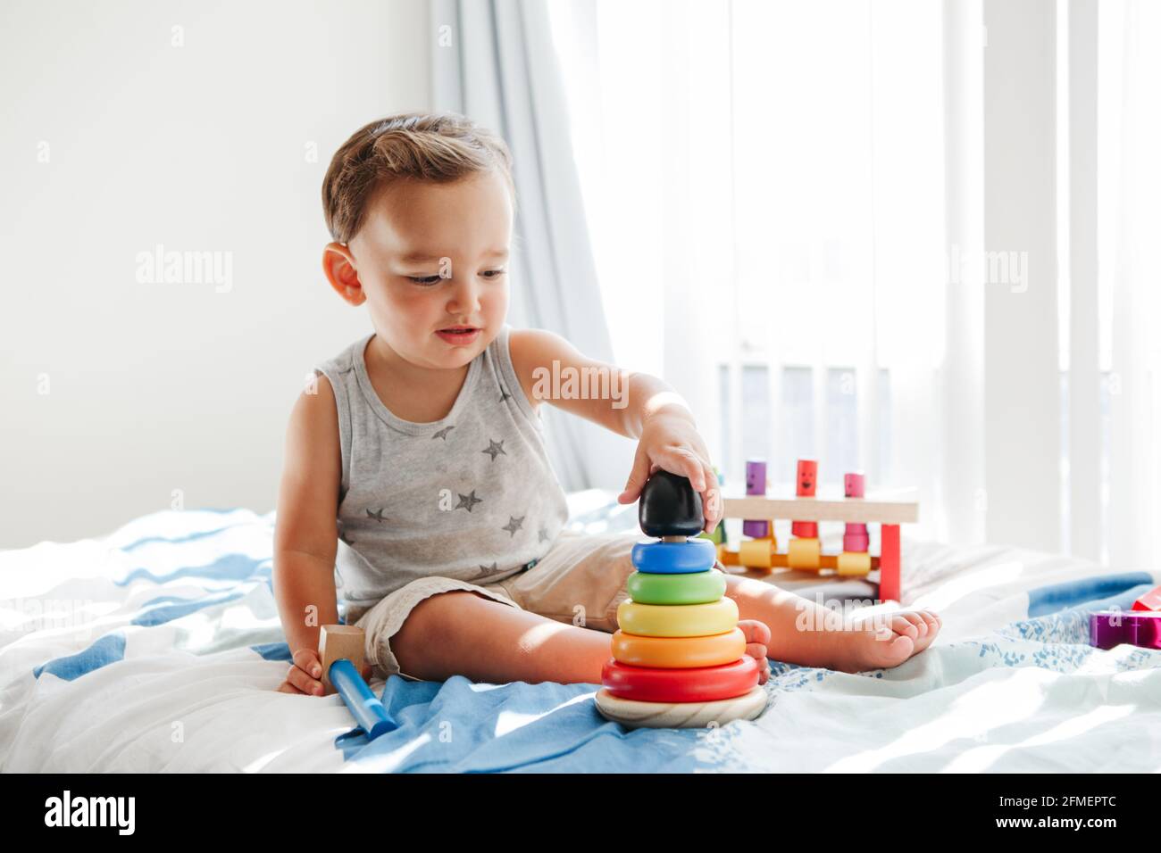 Nettes Baby Kleinkind spielen mit Lernspielzeug Pyramide Stapelblöcke zu Hause. Frühes Alter Montessori Ausbildung. Kinder Hand Gehirn Spaß Entwicklung Aktivität Stockfoto