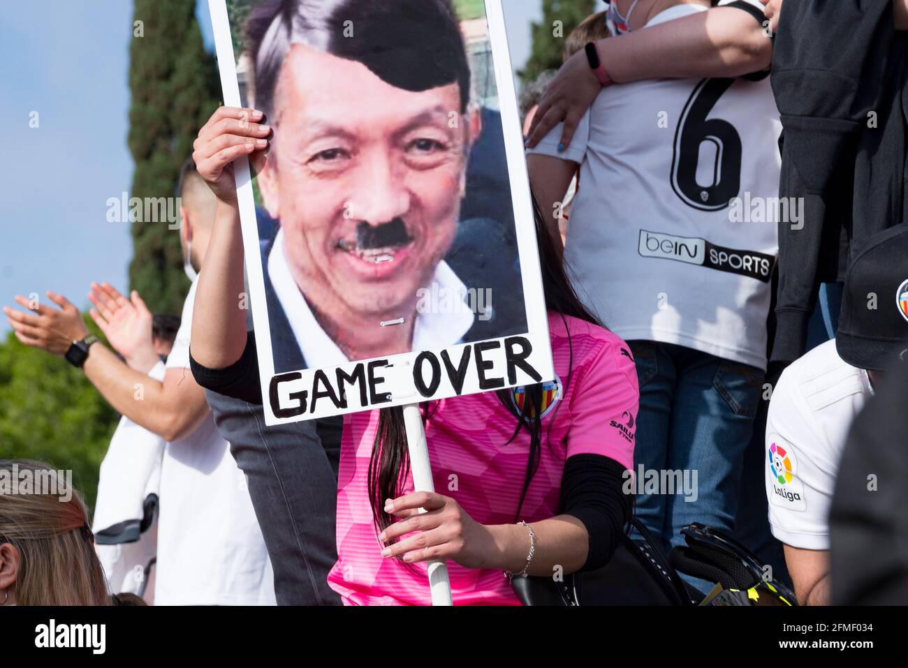 Ein Fan hält ein Plakat mit einem Porträt von Peter Lim, der Adolf Hitler während der Demonstration simuliert.Fans des FC Valencia protestieren gegen die Geschäftsführung von Präsident Peter Lim, dem der Club und die Firma Meriton Holdings gehören. Die Unterstützer riefen den wohlhabenden singapurischen Eigentümer Peter Lim dazu auf, seine Aktien zu verkaufen und den Club zu verlassen, den er seit 2014 besitzt. Stockfoto