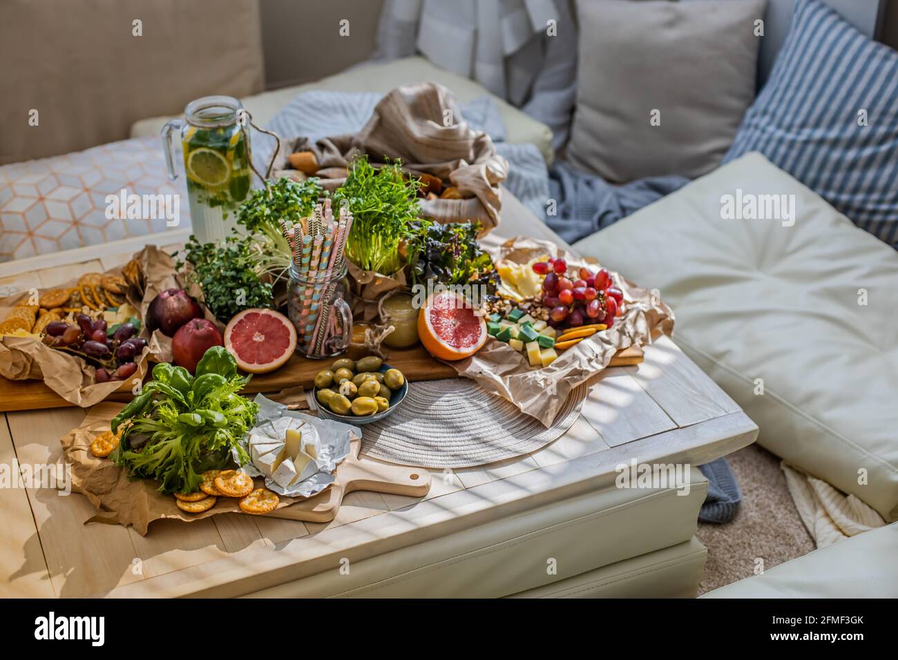 Serviertisch mit einem gesunden Getränk im gemütlichen Boho scandi Interior. Hippie Geburtstagsfeier Urlaub Stockfoto