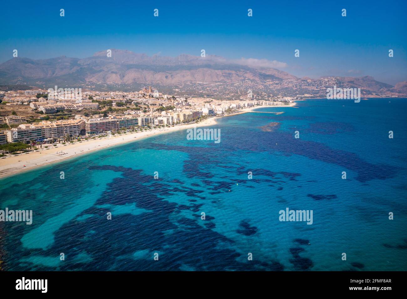 Sonniger Tag, Sommer, spanische Mittelmeerküste Landschaft. Strand mit türkisfarbenem Wasser. Touristische Sonne und Strand Wahrzeichen in Alicante, Spanien Stockfoto