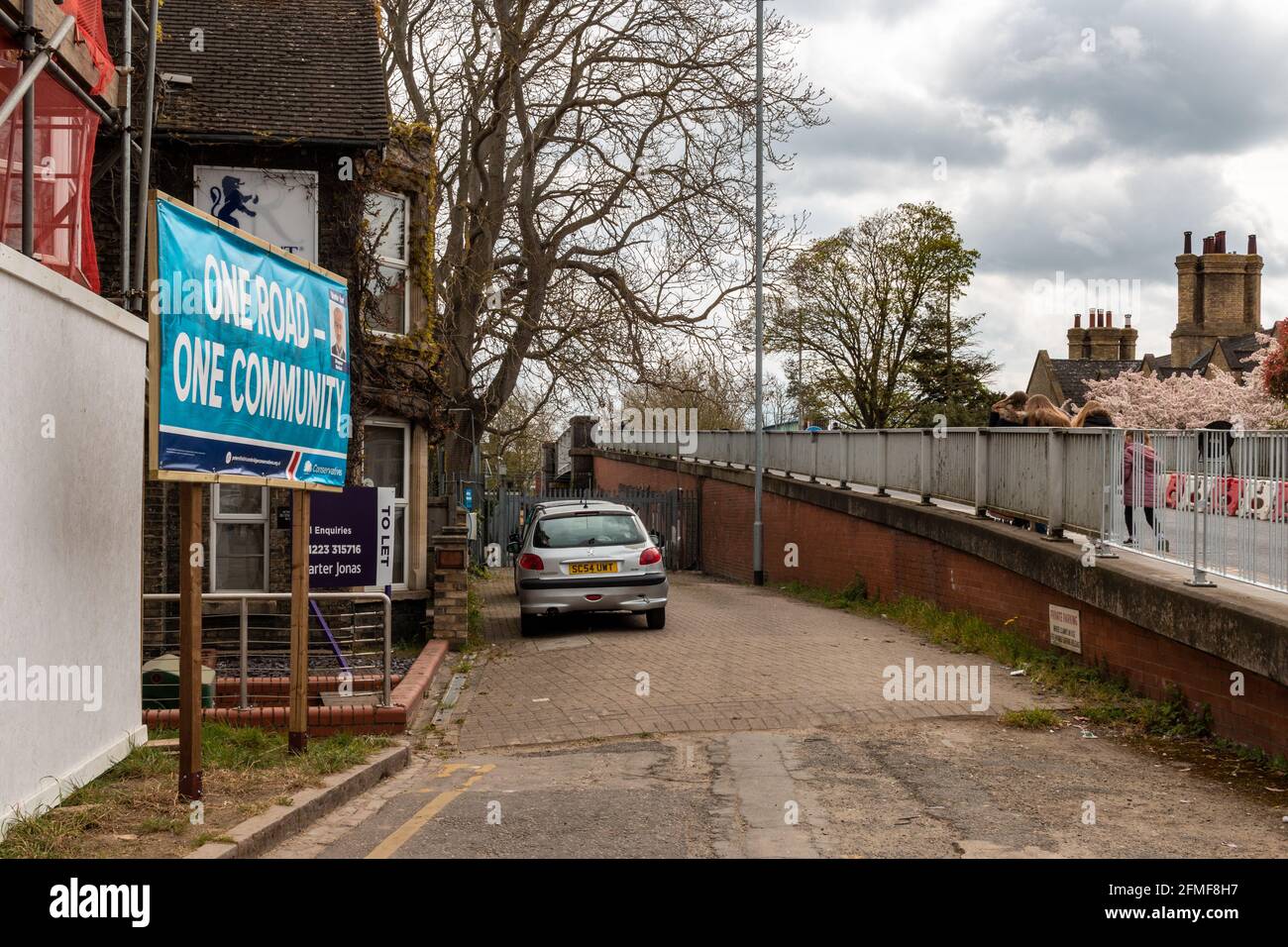 Ein lokaler Wahlkampf der konservativen Partei, der neben der Mill Road Bridge hortet. Der Slogan lautet: Eine Straße, eine Gemeinschaft. Mill Road, Cambridge, Großbritannien. Stockfoto
