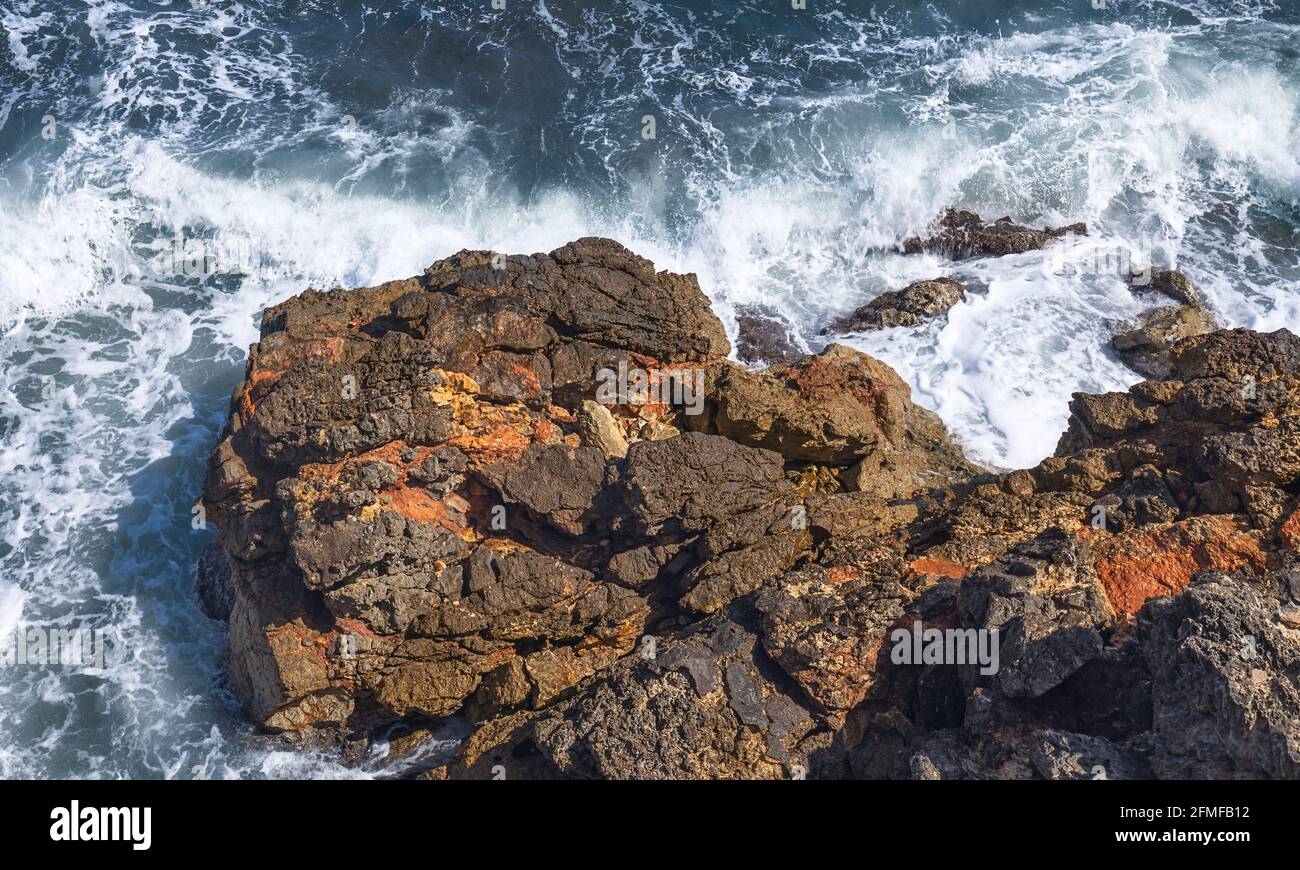Draufsicht auf Wellen, die in das riesige Rocky Promontory in Amewtlla de Mar, Costa Daurada, Katalonien, stürzen Stockfoto