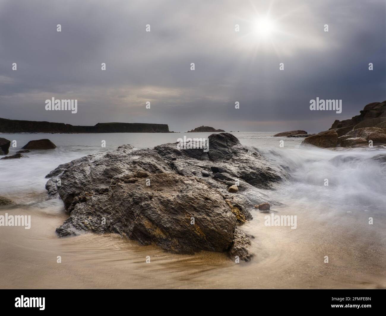 Lange Belichtung der schönen Szene von Wellen an der Küste mit schönem Horizont und bewölktem Himmel bei Sonnenuntergang. Stockfoto