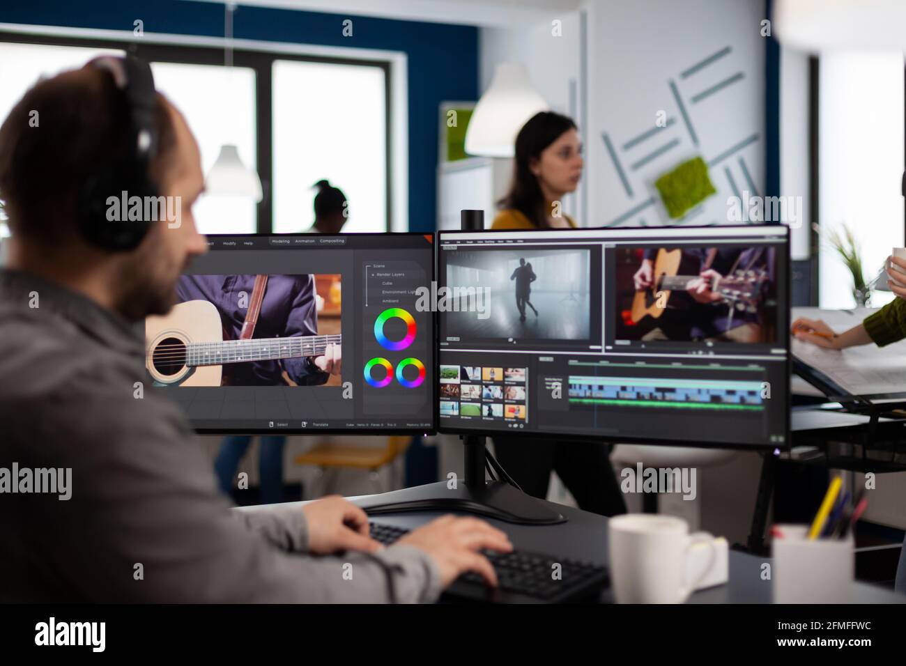 Der Videohersteller hört Musik über Kopfhörer und bearbeitet Filme mithilfe von Postproduktions-Software, die im Büro einer Kreativagentur arbeitet. Videofilmmontage auf dem Computer in Multimedia-Unternehmen Stockfoto