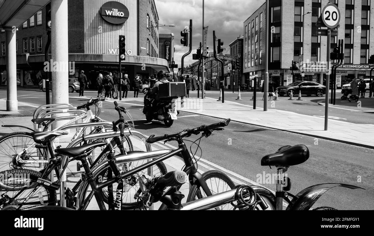 Kingston upon Thames London, Mai 07 2021, Fahrräder, die am Straßenrand mit EINEM Wilko Discount Store im Backgorund in EINER Town Center High Street geparkt sind Stockfoto