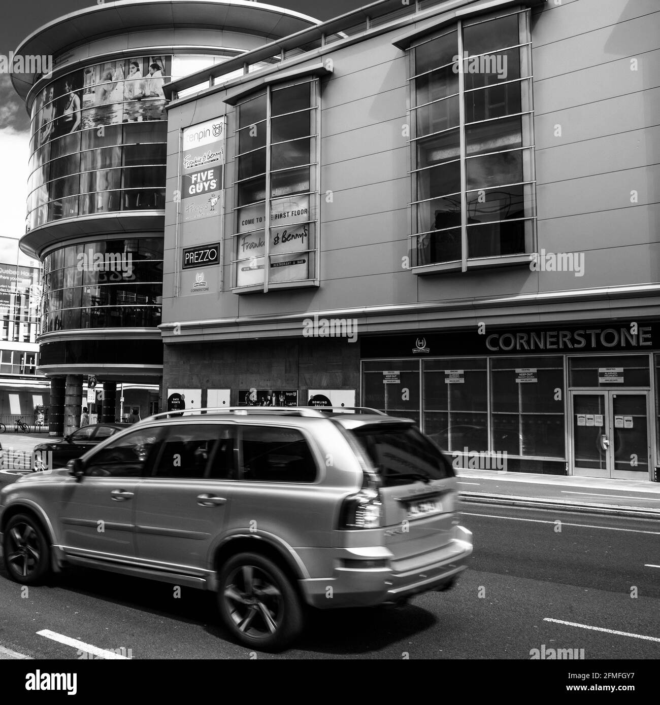 Kingston upon Thames London, Mai 07 2021, Autos oder Fahrzeuge passieren das Handelsgebäude moderner Architektur an EINER High Street im Stadtzentrum Stockfoto