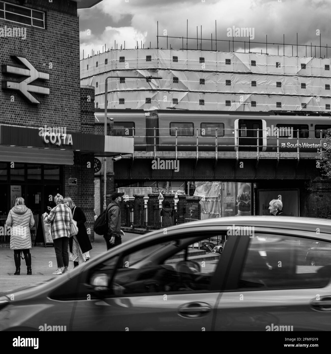 Kingston upon Thames London, Mai 07 2021, Eisenbahnzug über EINE Brücke am Bahnhof Kingston mit EINEM Costa Coffee Shop und Menschen Stockfoto
