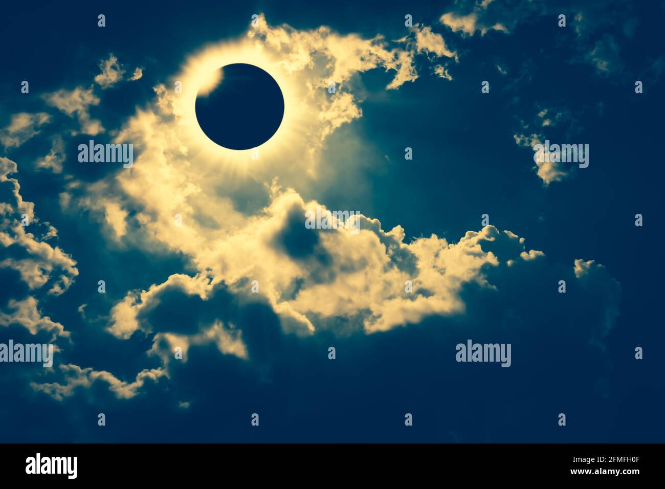 Erstaunliches wissenschaftliches Naturphänomen. Totale Sonnenfinsternis mit Diamantring-Effekt, der am Himmel mit dunklen Wolken leuchtet. Abstrakt fantastische Hintergrund von Stockfoto