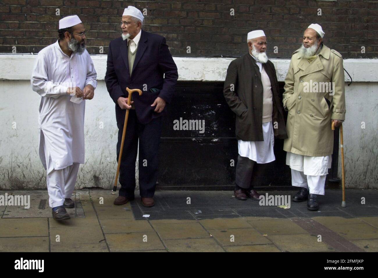 Männer reden vor der Moschee in einer Backsteingasse. 4/10/01 pilston Stockfoto