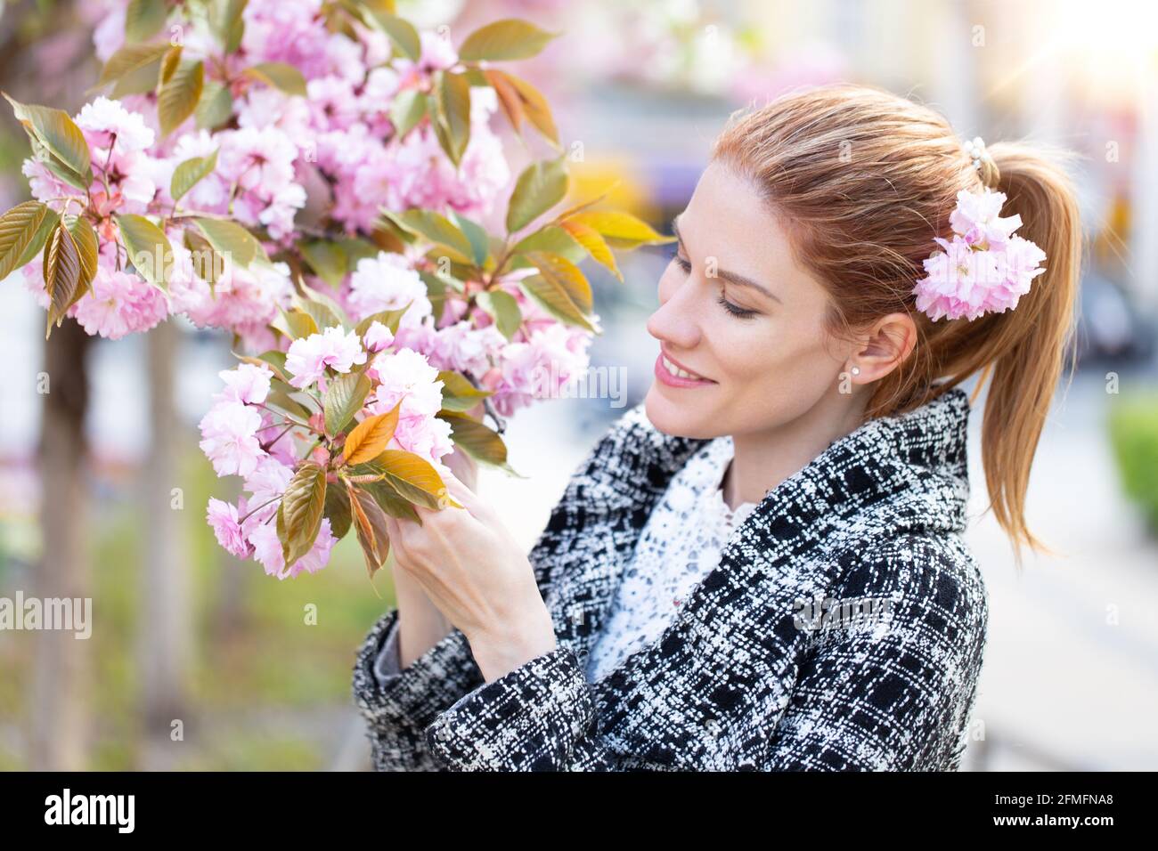 Junge kaukasische Rothaarige Frau mit Kirschbaumblütenporträt Stockfoto