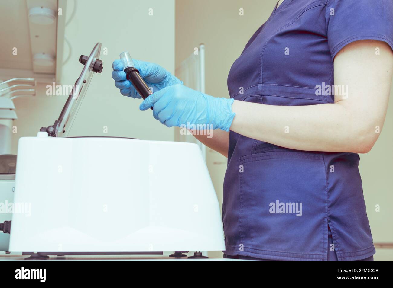 Arzt mit Reagenzgläsern an der Plasmazentrifuge Stockfoto