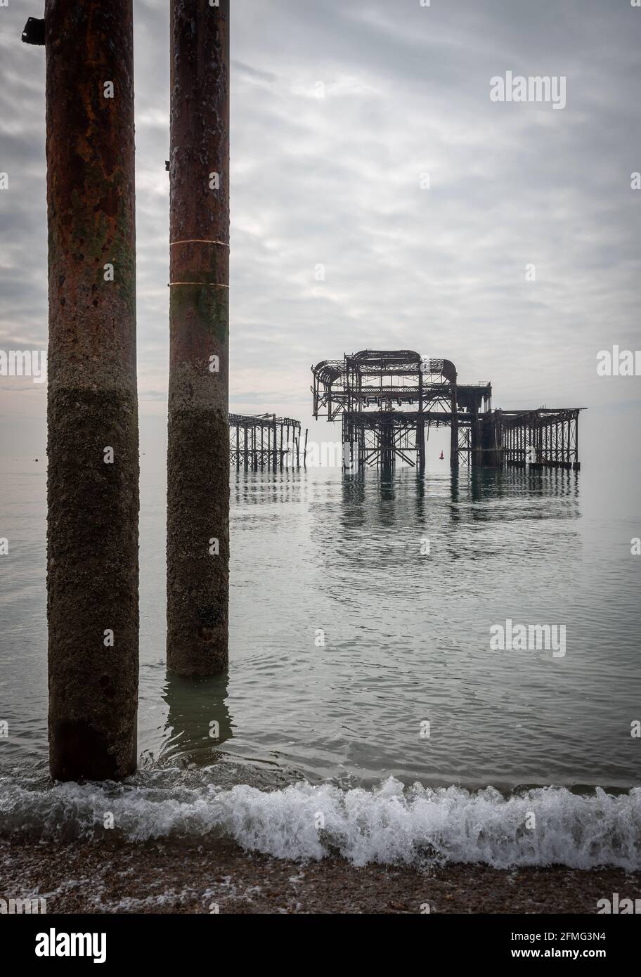 Die traurigen Ruinen von Brighton's West Pier auf einem ungewöhnlich Ruhiges Meer Stockfoto