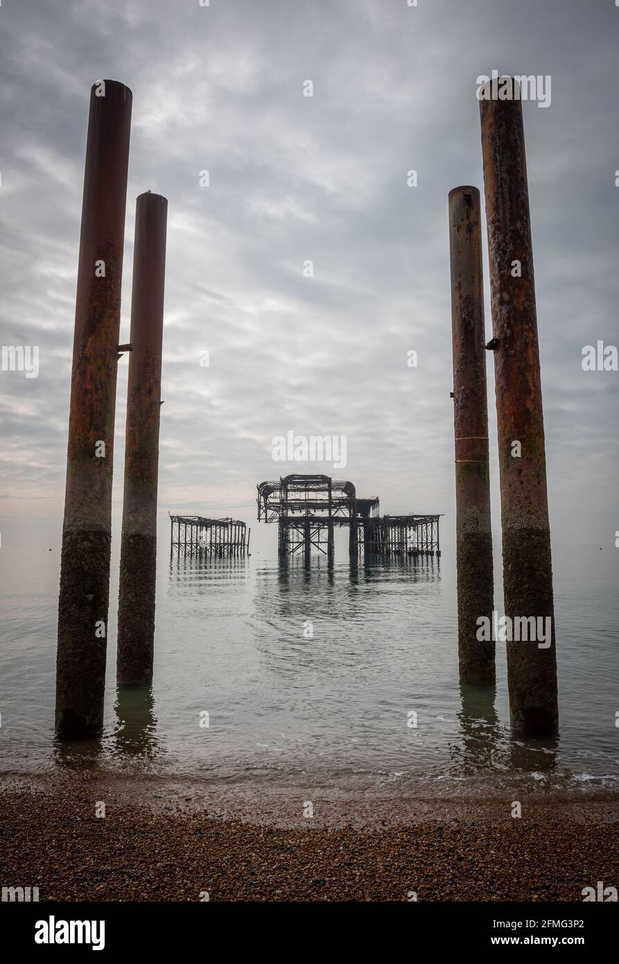 Die traurigen Ruinen von Brighton's West Pier auf einem ungewöhnlich Ruhiges Meer Stockfoto