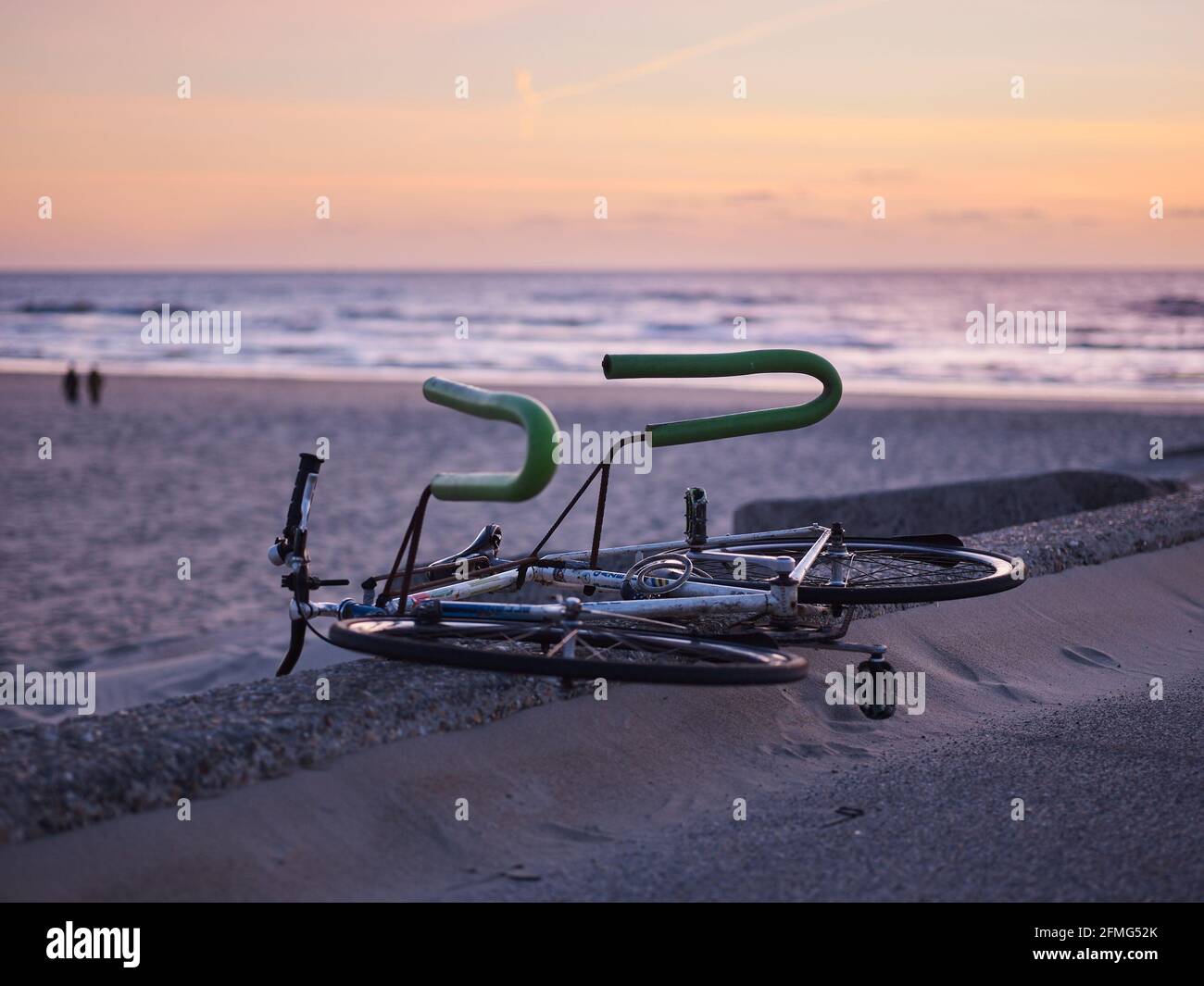 Fahrrad zu transportieren Surfbrett liegen am Kai in der Nähe des Meeres während des Sonnenuntergangs. Stockfoto