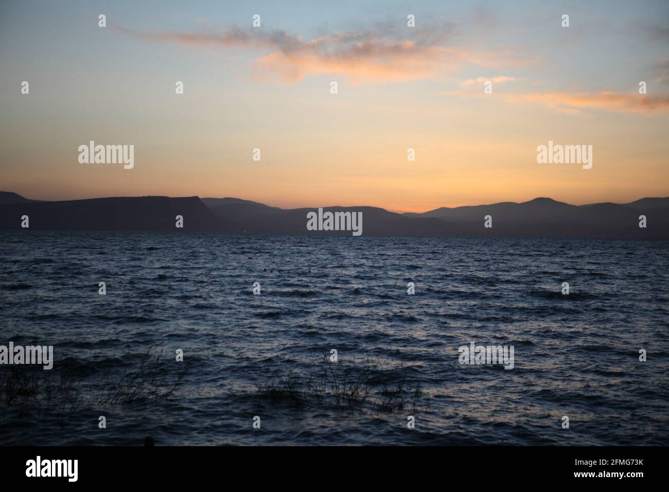 Sonnenuntergang über dem See von Galilee, die Lower Galilee Hills ist auf der anderen Seite zu sehen und Wolken sind in der dramatischen bunten Himmel über Stockfoto