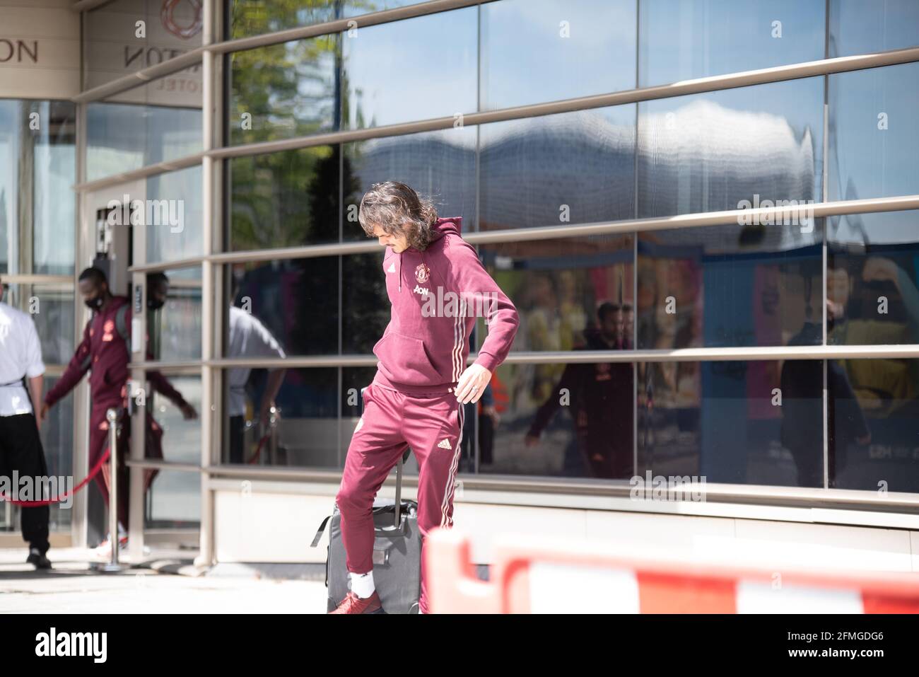 Birmingham, Großbritannien. Mai 2021. Edinson Cavani kämpft mit seinem Koffer, als er gegen Mittag des 9. Mai das Clayton Hotel im Stadtzentrum von Birmingham verlässt, bevor er gegen Aston Villa antreten wird. Kredit: Ryan Underwood/Alamy Live Nachrichten Stockfoto