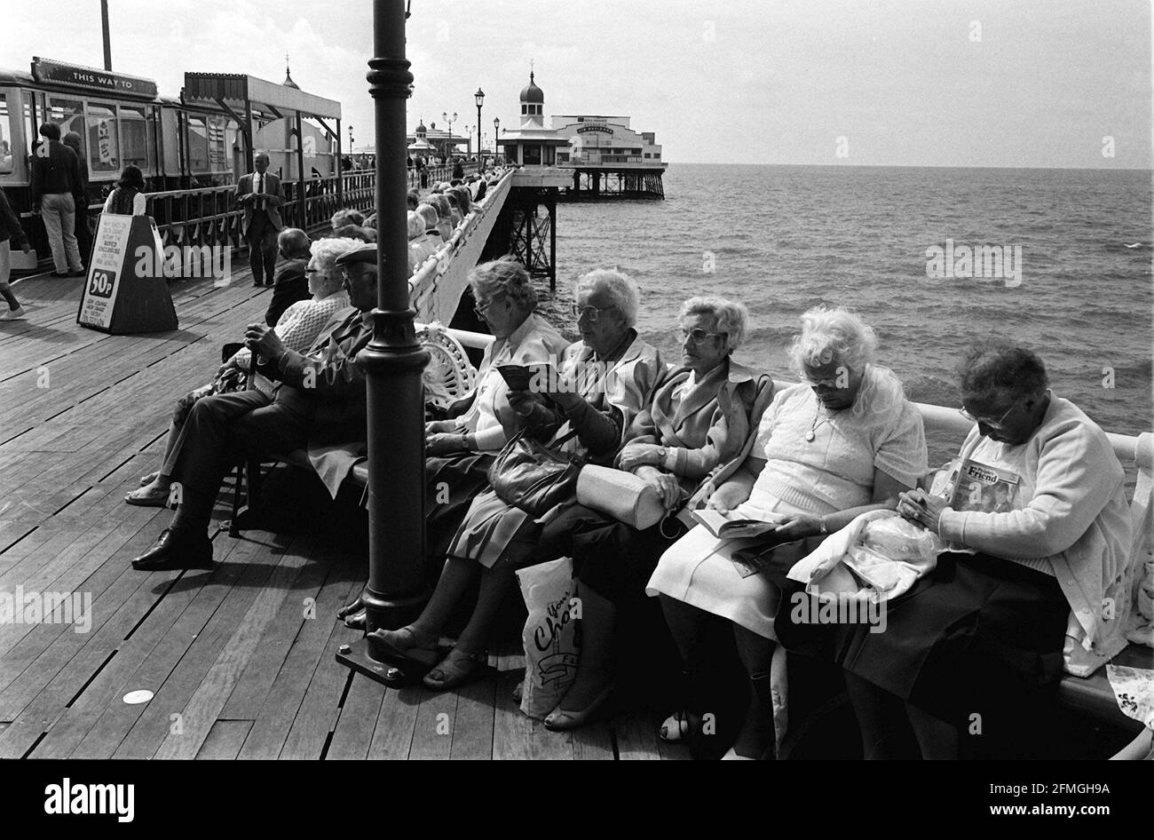 Die elderigen Urlauber sitzen am Pier am Blackpool Seaside Und Holiday ResortDBase Stockfoto